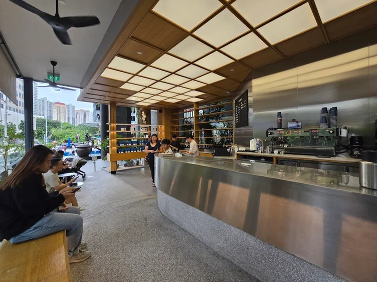 Modern interior of Alchemist at The Heeren, Singapore, with stainless steel counter and large windows.