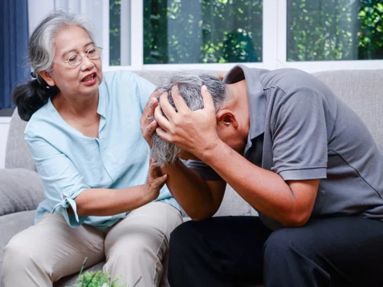 Elderly woman comforting elderly man showing early signs of memory loss highlighting the importance of managing alzheimer's disease risk.