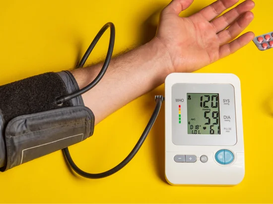 Using a digital blood pressure monitor to check systolic and diastolic readings at home.
