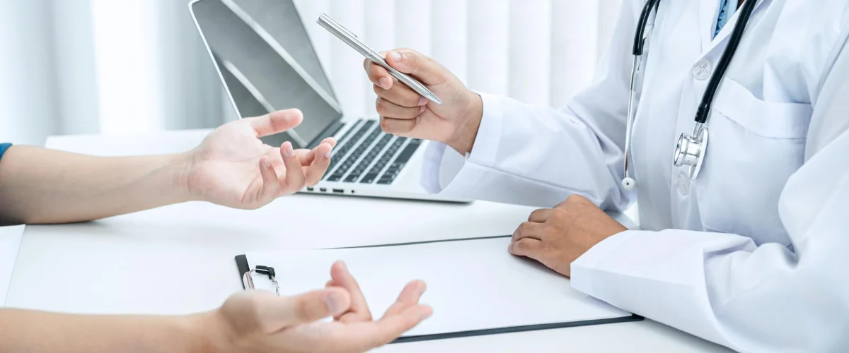 Doctor having a consultation session with patient and answering questions posed to him.