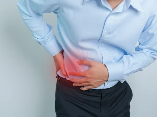 Man holding right side in pain, suggesting liver discomfort from possible fatty liver.