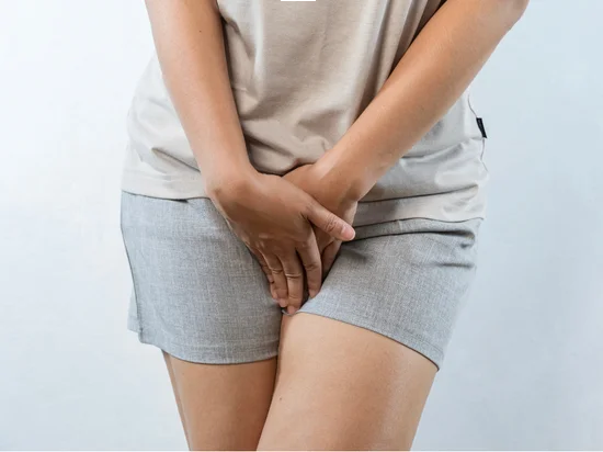 Woman holding pelvic area, showing discomfort from vaginal yeast infection symptoms.