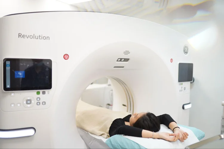 Asian woman undergoing a computed tomography calcium score scan as part of basic health screening in singapore.