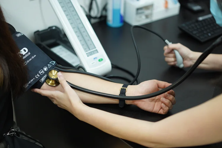 ATA Medical doctor measuring a patient’s blood pressure to assess hypertension as part of general and chronic disease consultation.