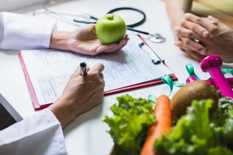 Doctor giving nutrition advice with fruits vegetables and fitness tools as part of longevity care.