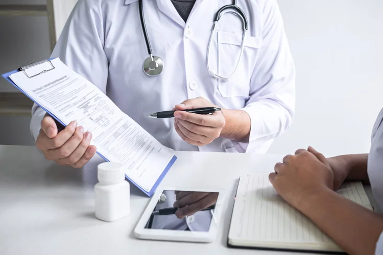 Doctor reviewing blood pressure report with patient during clinic consultation in Singapore.