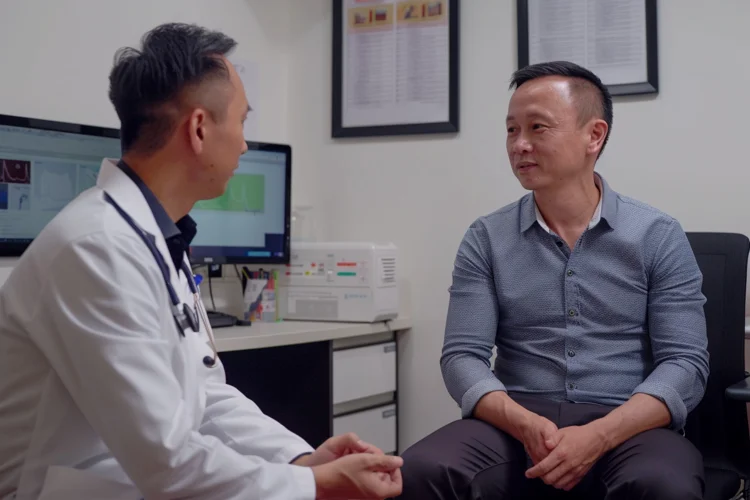 Doctor reviewing the results of liver elastography with a middle-aged Singaporean man during a follow-up consultation.