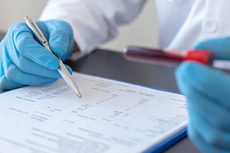 Doctor reviewing Varicella immunity blood test results with labelled tube and patient report.
