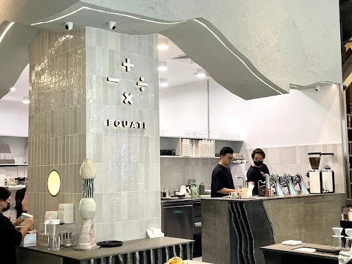 Modern interior of Equate Coffee Orchard Central with upside-down tree and coffee bar.