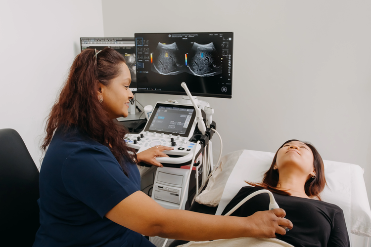 Female sonographer performing an abdominal ultrasound scan on a patient at ATA Medical Novena clinic.