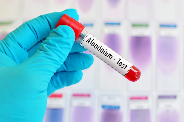 Gloved hand holding a blood sample labeled 'Aluminium Test' for detecting aluminium levels in blood and assessing toxicity.