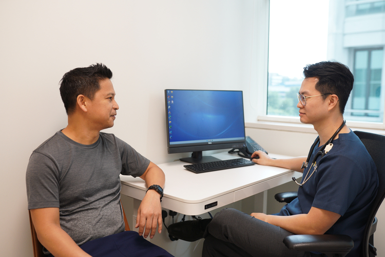 Patient consulting male doctor about premature ejaculation at a clinic in Singapore.