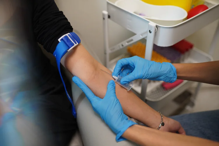 Person receiving a blood draw in a clinic for a serum aluminium test to assess long-term exposure and aluminium accumulation in the body.