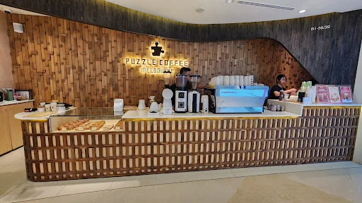 Front counter of Puzzle Coffee at ION Orchard with sustainable wood and Melbourne-style design.