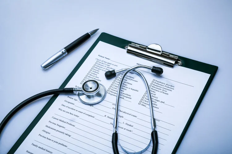 Stethoscope with medical form on clipboard to assess most suitable type of health screening package.