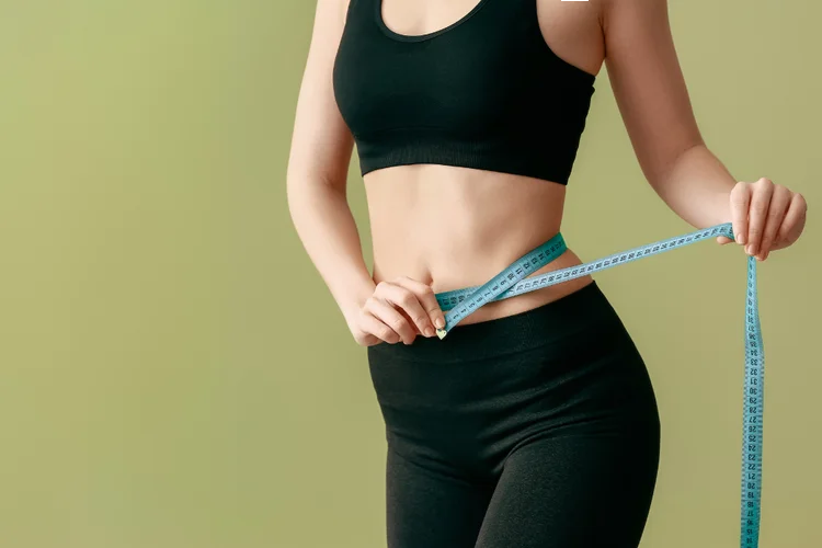 Woman measuring waist to show weight loss benefits of Tirzepatide for obesity treatment.