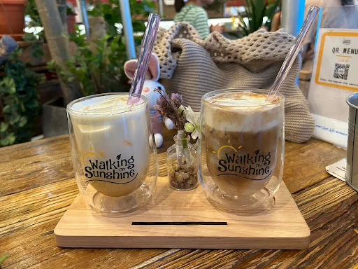 Specialty coffee at Walking On Sunshine Singapore served as iced drinks in glass cups on a wooden tray.