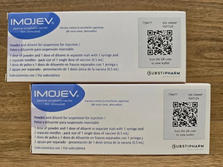 两盒 Imojev 日本脑炎疫苗的包装盒叠放在木桌上